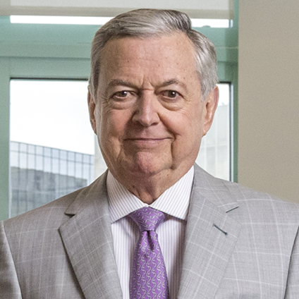 Close-up of man dressed in gray suit, white shirt and purple tie