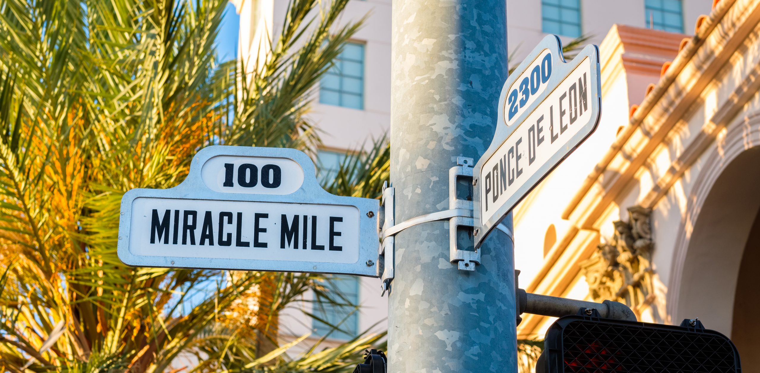 Street signs showing 100 Miracle Mile and 2300 Ponce de Leon
